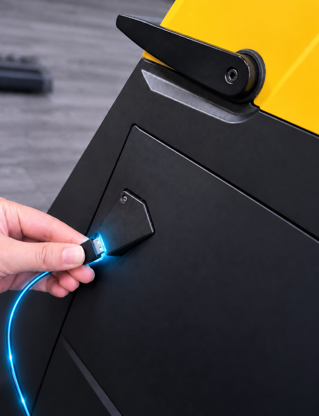 A hand plugging the glowing blue USB cable into the bike's port